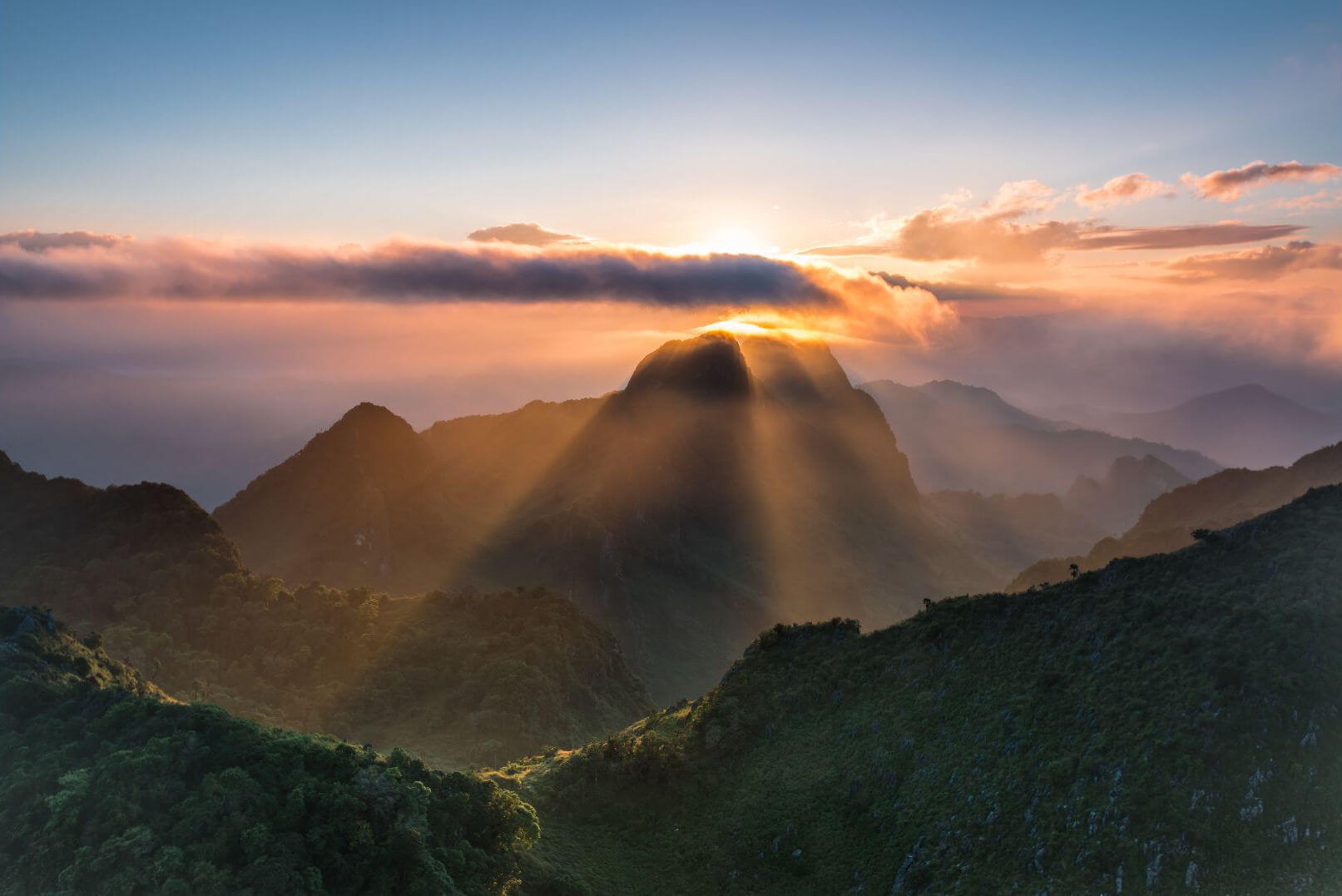 Sunrise illuminating the limestone cliffs of Doi Chiang Dao above the valley