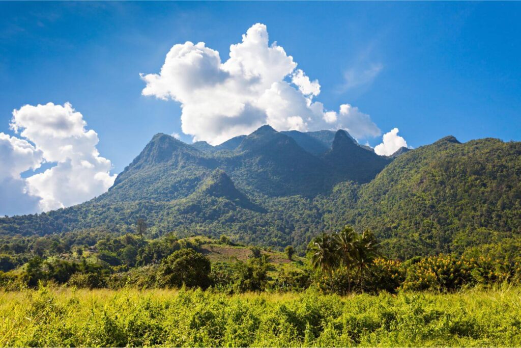 off-path-thailand-chiang-dao-mountain-clouds Limestone cliffs of Chiang Dao under clear blue skies and scattered white clouds in northern Thailand
