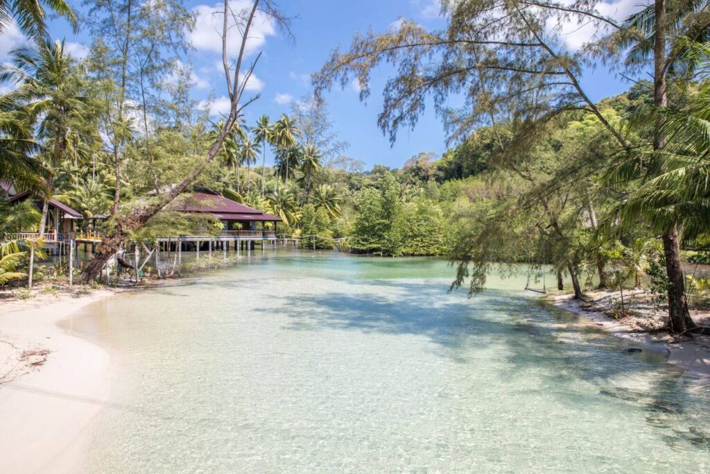 off-path-thailand-koh-kood-bay-trees Tranquil bay on Koh Kood with calm turquoise water, shaded by trees along the shore