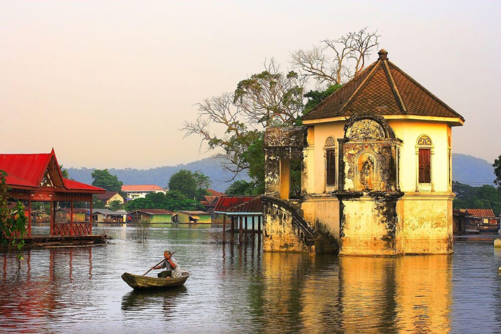 Wat Ubolsatharam temple in Uthai Thani Thailand reflecting in the Sakae Krang River at sunrise