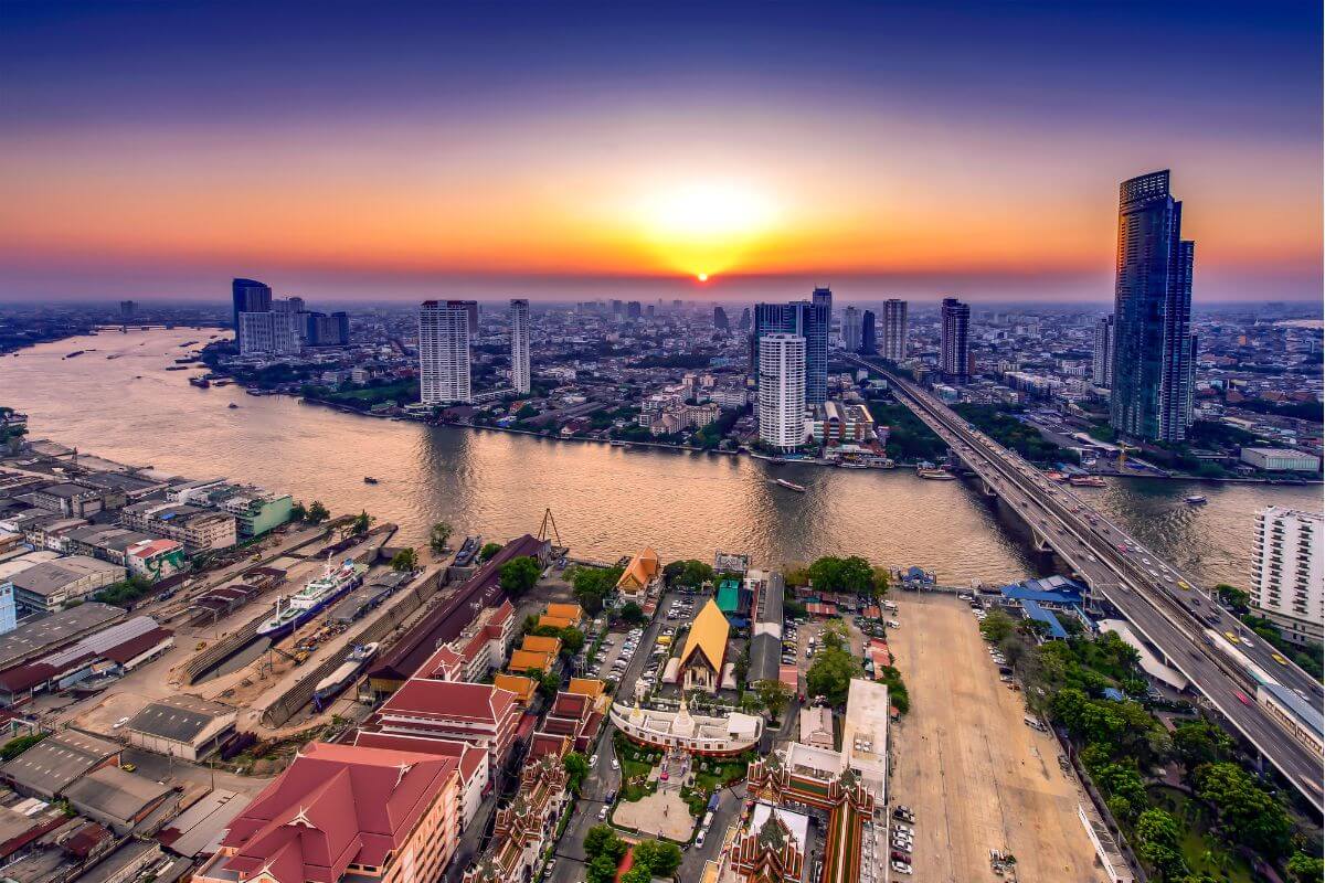 Bangkok skyline and Chao Phraya River with a long bridge crossing the water, showing the city’s scale and key transport corridor
