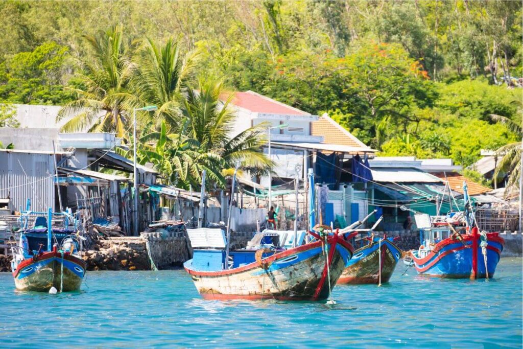 wooden stilt houses and small fishing boats in a peaceful coastal village