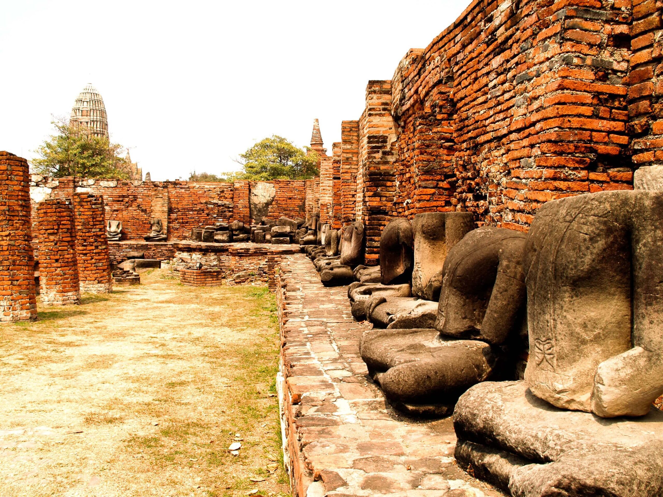 Headless stone Buddha statues seated on brick pedestals in Ayutthaya Historical Park