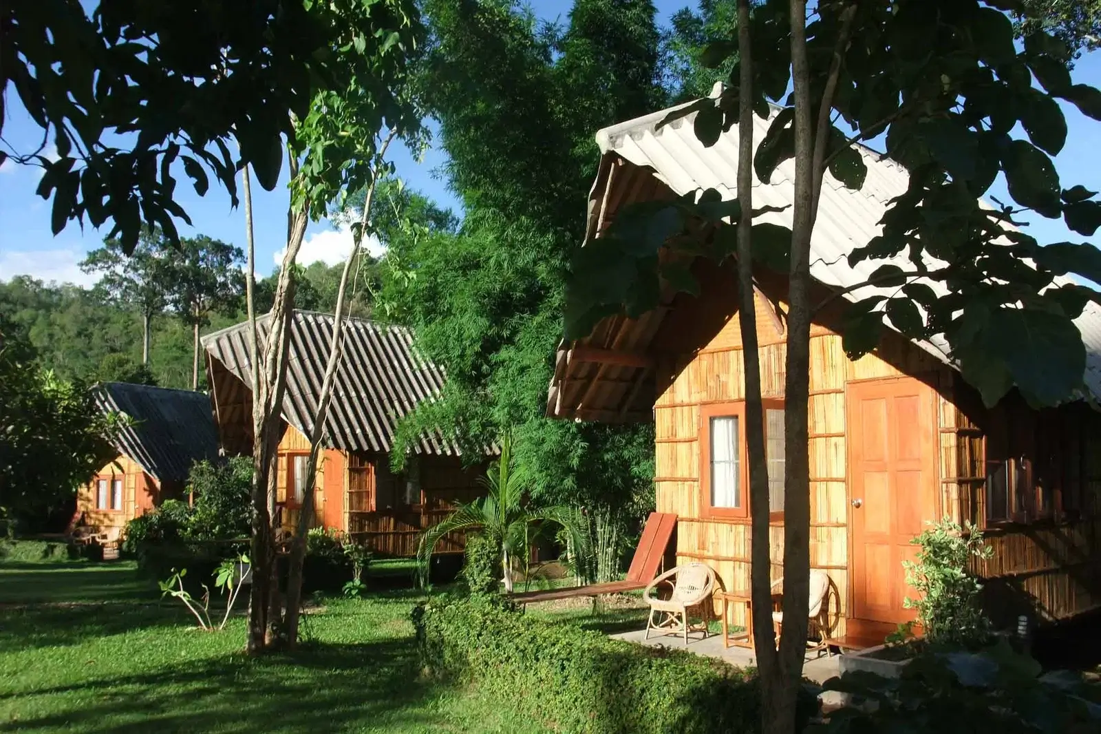 Wooden bungalow cabins at Chiang Dao Nest with mountain backdrop