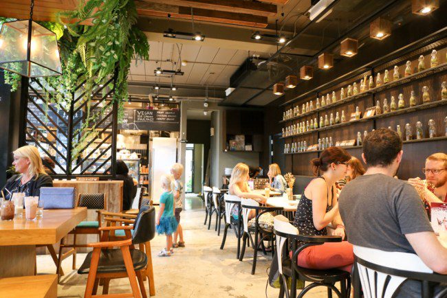 Veganerie-Concept Cozy dining area and bakery display inside Veganerie, recognized among the best Bangkok vegetarian restaurants.