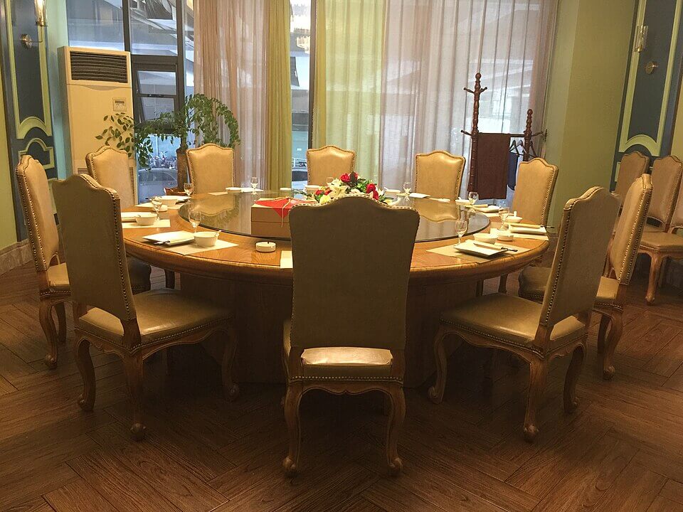 Old-school Chinese-Thai dining room with round tables and warm lighting.