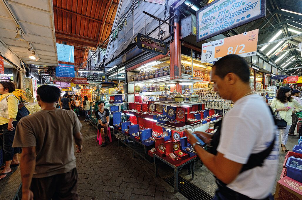 Chatuchak market walkway in Bangkok with stalls and shoppers, a budget-friendly local activity in 2026