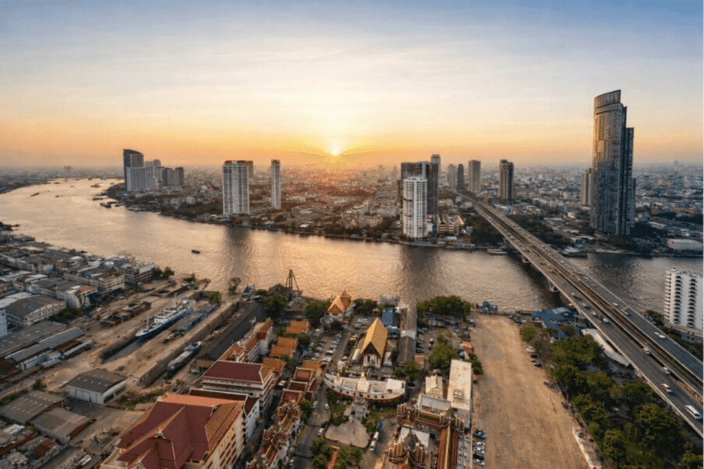 off-path-thailand-bangkok-riverside-crossing Chao Phraya River in Bangkok at sunrise with boats and riverside life, reflecting how to travel Bangkok on a budget