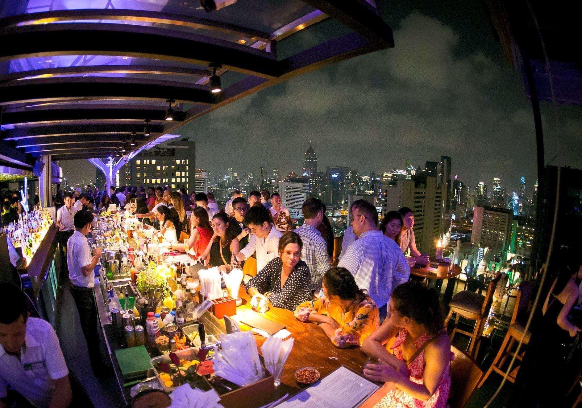Bangkok skyline view from Above Eleven rooftop at sunset with city lights beginning to turn on in Sukhumvit